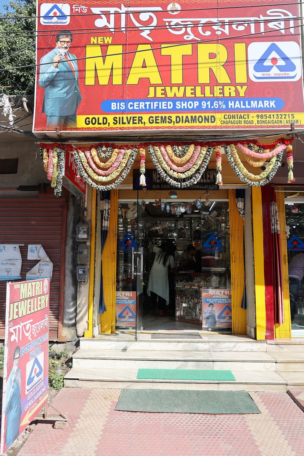 Storefront entrance of newMATRI JEWELLERY showing BIS 91.6% Hallmark sign on Chapaguri Road, Bongaigaon